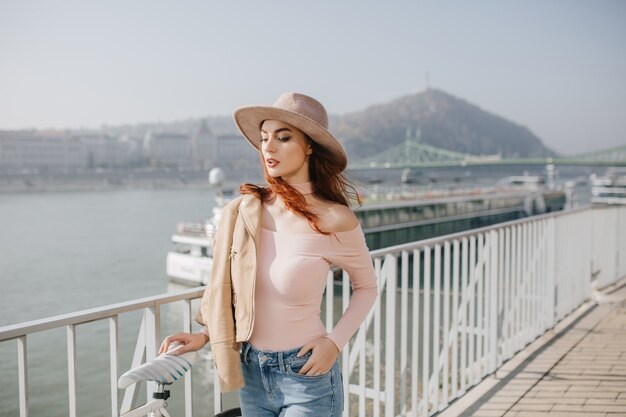 Inspired woman with ginger hair posing on mountains