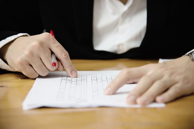 Instructor checking multiple choices answer sheet exam - education people working with paper test concept