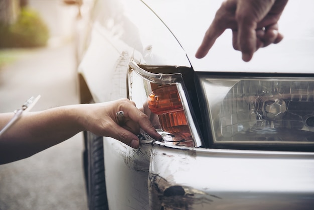 Foto gratuita agente assicurativo che lavora durante il processo di reclamo in loco in caso di incidente d'auto, persone e assicurazione auto