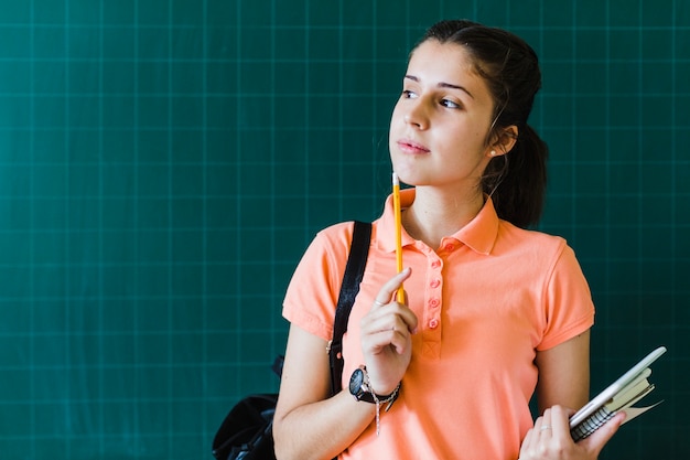 Intellectual student posing with blackboard