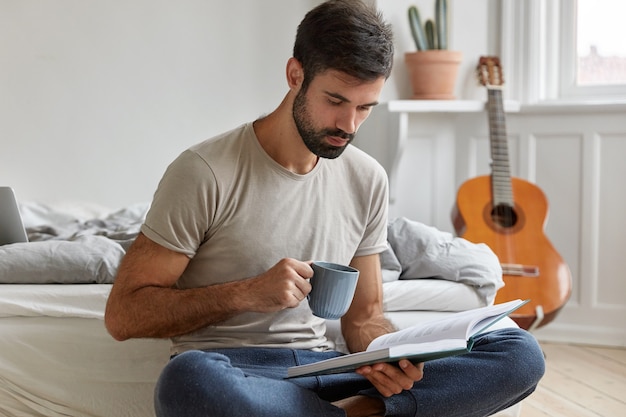 Free photo intelligent bearded guy posing at home while working