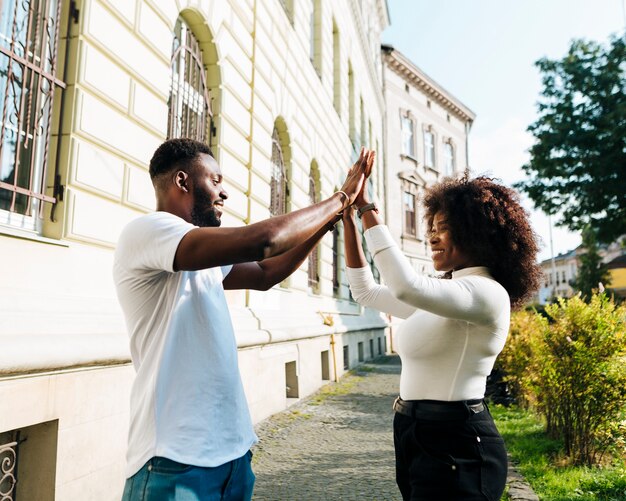 Intercultural friends clap their hands in the air