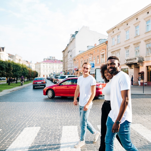 Free photo intercultural friends crossing zebra together