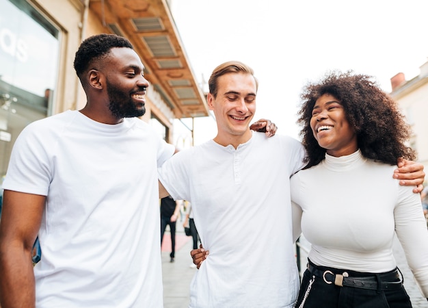  intercultural friends hugging and walking together