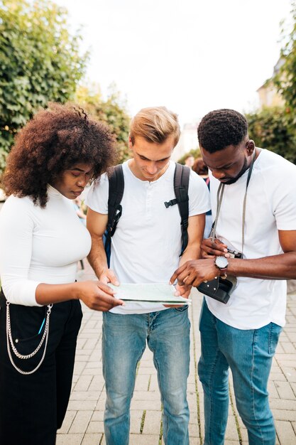 Intercultural friends looking at map together