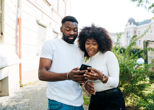 Intercultural friends looking at mobile