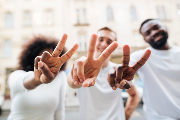 Free photo intercultural friends showing peace sign