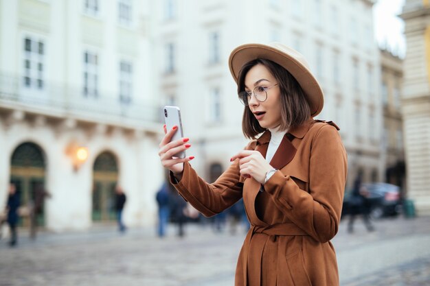 Interested beautiful young woman walking on the street in warm day