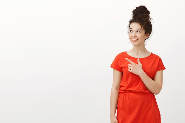 interested carefree woman with curly hair combed in bun