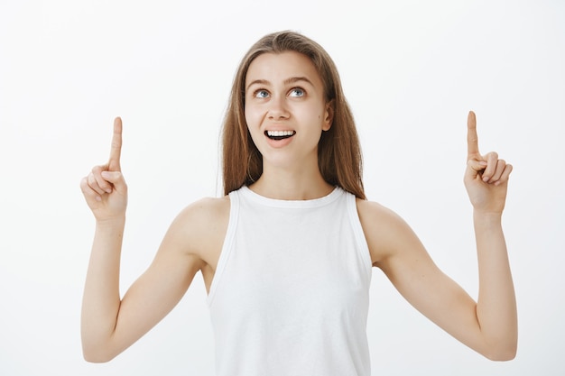 Interested, curious girl pointing fingers up and banner