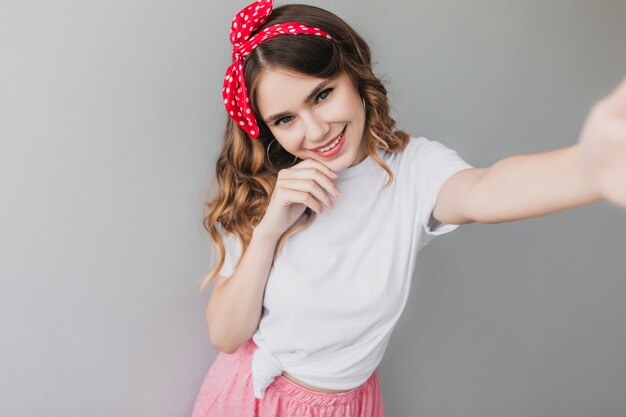 Interested curly young woman posing. amazing caucasian lady in romantic outfit making selfie.