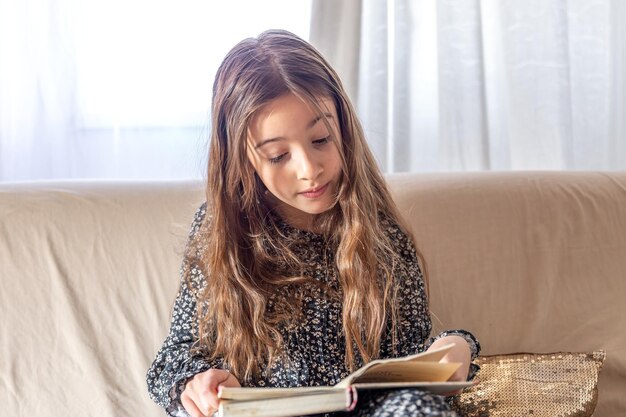 an interested girl is reading a book at home a girl and a book
