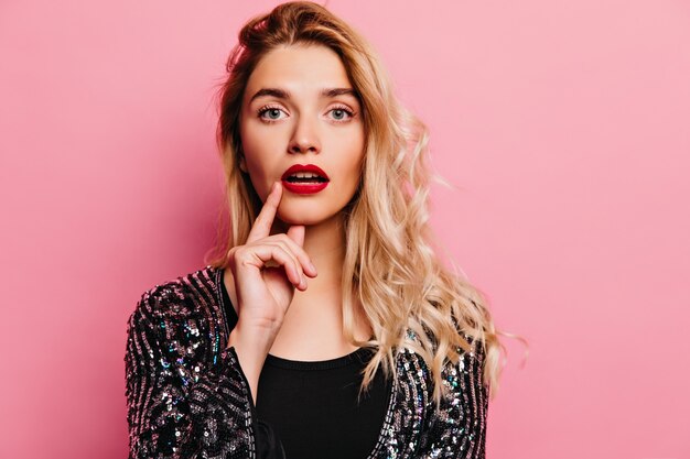 Interested gorgeous woman. Indoor photo of adorable blonde lady isolated on pink wall.