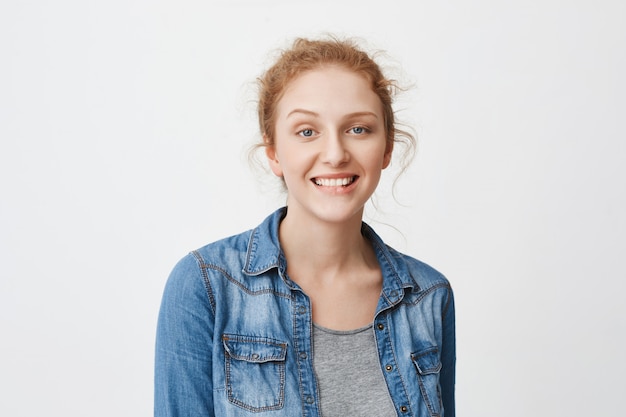 Femmina rossa caucasica allegra interessante con gli occhi azzurri che sorridono largamente