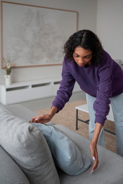 Free photo interior designer arranging pillows in home