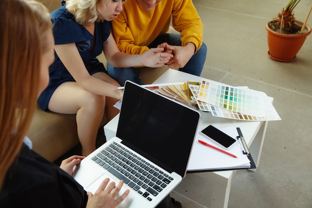 Free photo interior designer working with young couple.