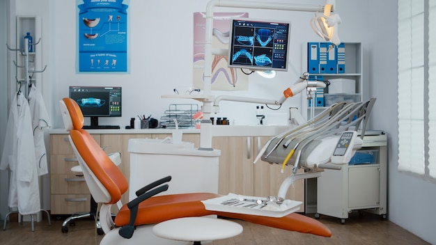 Interior of modern equipped dental office with x ray on monitors, dentist stomatology orthodontic workplace