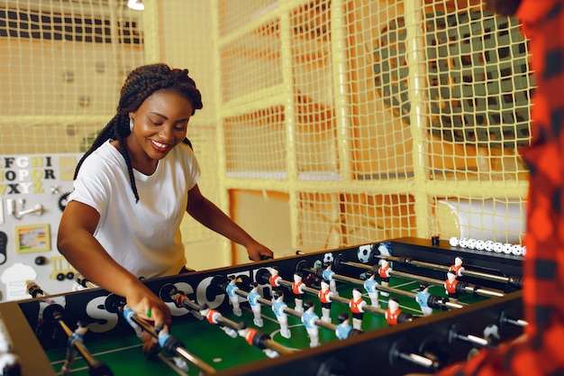 International couple playing a table football in a club