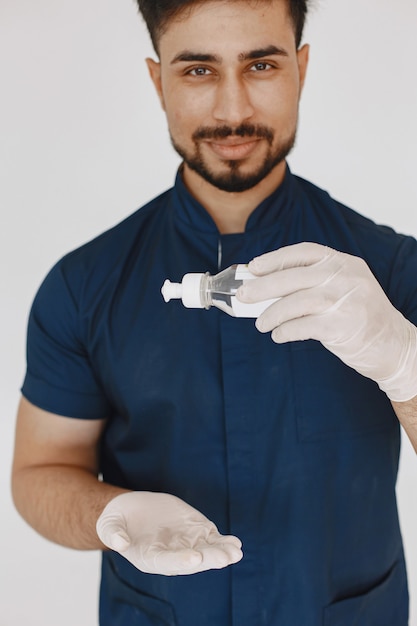 Foto gratuita studente internazionale di medicina. uomo in uniforme blu. dottore con antisettico.