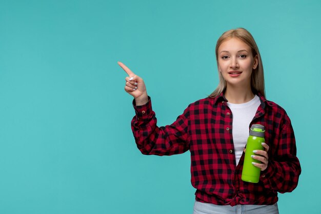 国際学生の日かわいいブロンドの女の子の赤いチェックシャツ幸せな保持緑のフラスコ