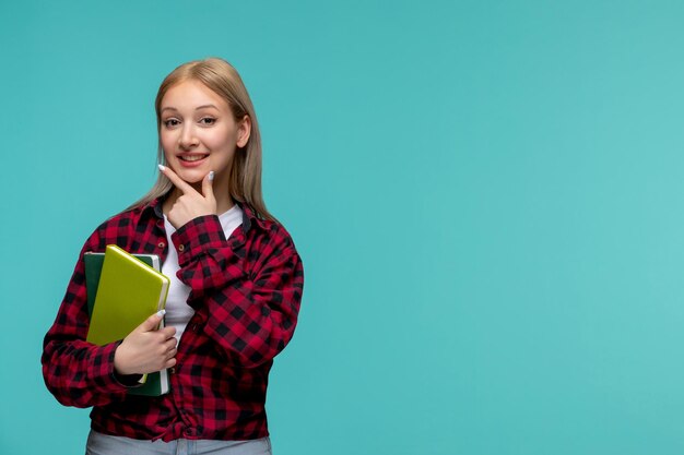 国際学生の日赤いチェックのシャツを着た若いかわいい女の子が顔に触れて本を持っています