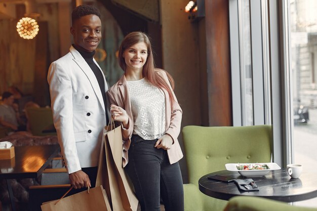 Internationals people standing in a cafe with shopping bags