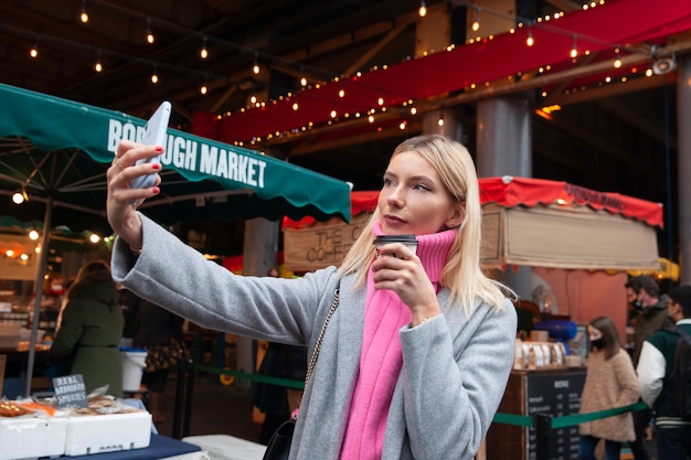 Foto gratuita celebrità di internet che si fa un selfie al mercato