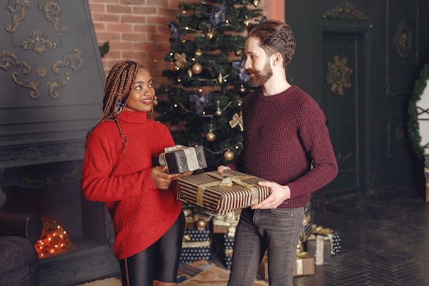 Free photo internetional people at home. couple in a christmas decorations. african woman and caucasian man.