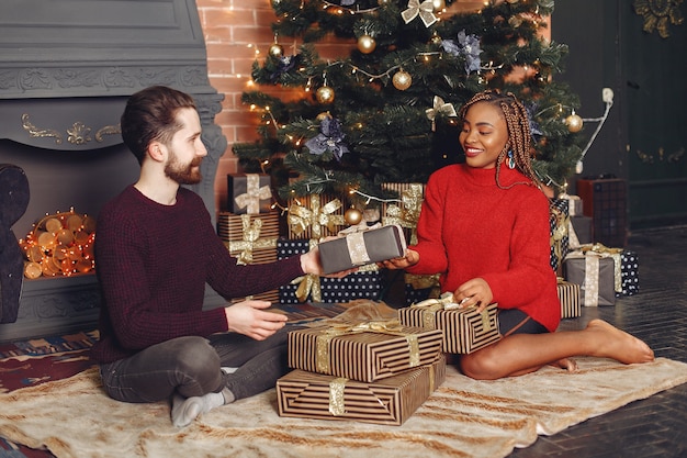 Internetional people at home. Couple in a Christmas decorations. African woman and caucasian man.