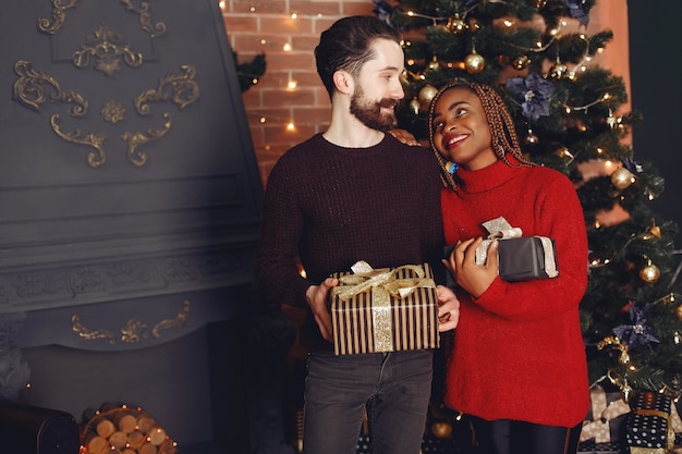 自宅のインターネットの人々。クリスマスの飾りのカップル。アフリカの女性と白人の男性。