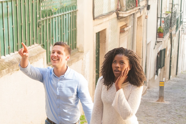 Free photo interracial couple of tourists excited with landmarks