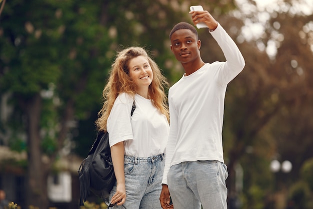 Interracial 학생들은 재미 있고 공원에서 유쾌하게 웃는다