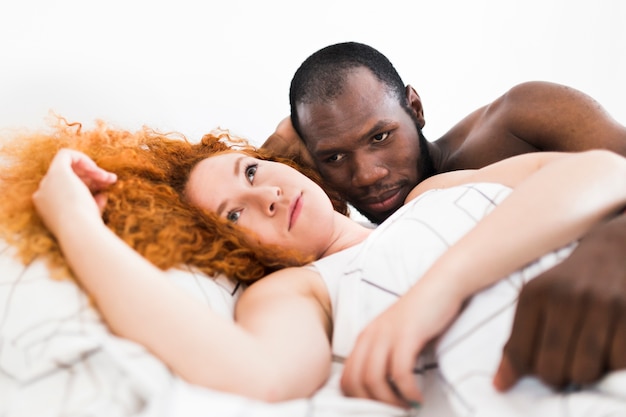 Интимный момент межрасовой пары в постели