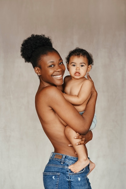 Free photo intimate portrait of beautiful mother holding her baby