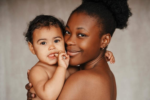 Free photo intimate portrait of beautiful mother holding her young child