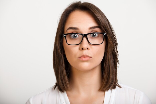 Intrigued brunette woman in glasses, express surprise