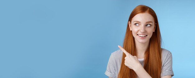 Free photo intrigued goodlooking redhead joyful curious girl watching looking upper left corner interested