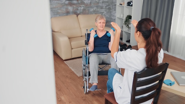 Free photo invalid old woman in wheelchair doing rehab training with support from doctor. disabled handicapped old person recovering professional help nurse, nursing retirement home treatment and rehabilitation