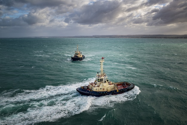 Investigative boats sailing in the turquoise ocean under the cloudy sky