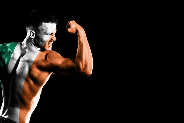 Ireland flag on handsome young muscular man black background