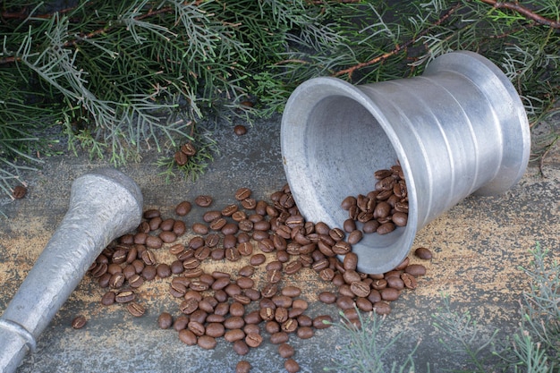 An iron bucket with coffee beans on marble background. High quality photo