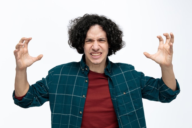 Free photo irritated young handsome man looking at camera doing roar and tiger paws gesture isolated on white background