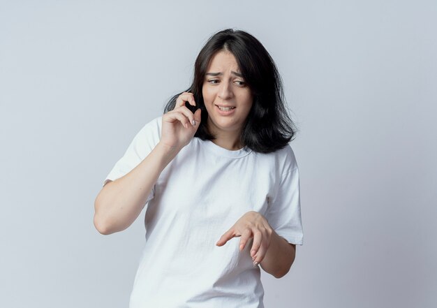 Irritated young pretty caucasian girl looking at side and keeping hands in air isolated on white background with copy space