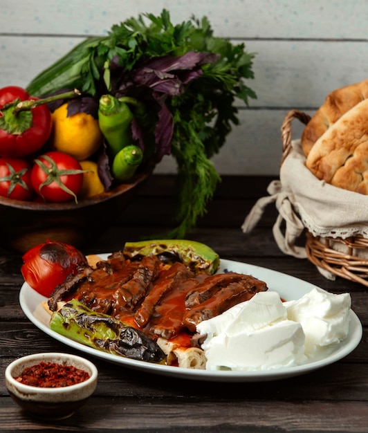 Iskander doner with vegetables on a wooden table