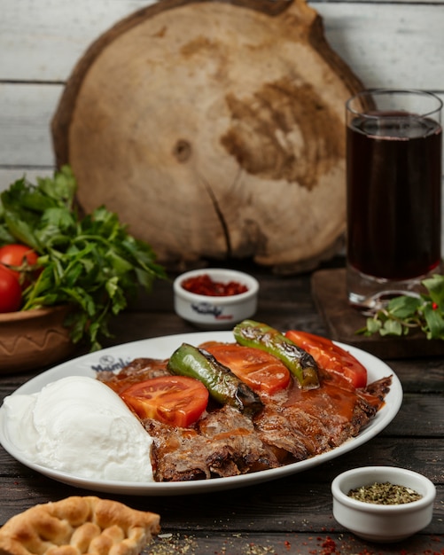 iskender kebab garnished with tomato sauce, pepper, served with yoghurt