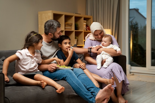 Foto gratuita famiglia islamica sul divano a tutto campo