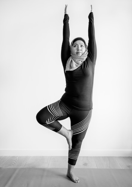 Free photo islamic woman doing yoga in the room