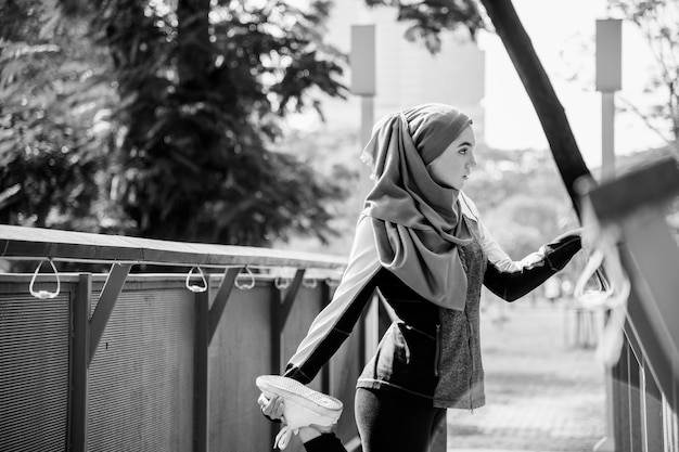 Бесплатное фото Исламская женщина, растянувшаяся после тренировки в парке