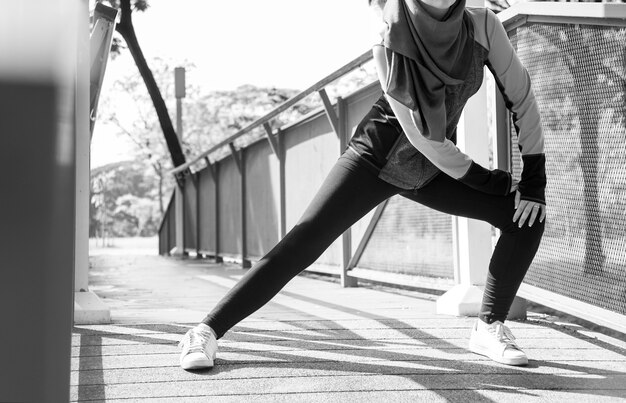 Islamic woman stretching after workout at the park