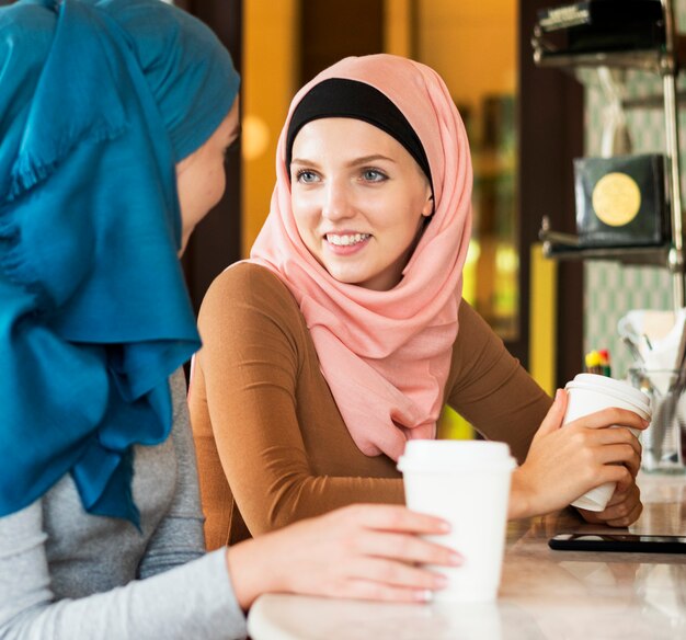 Друзья исламских женщин наслаждаются и разговаривают в кафе